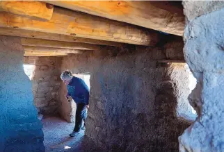  ?? ?? Lorri Chmilar, from Britsh Columbia, walks through a reconstruc­ted house on the mesa top portion of the Puye Cliff Dwellings.