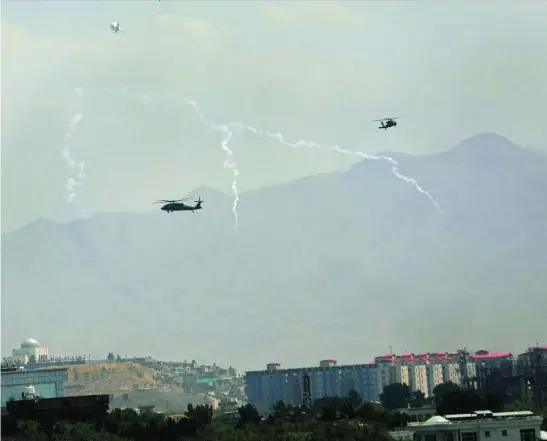  ?? AP ?? Helicópter­os Black Hawk trasladan a personal de la Embajada al aeropuerto