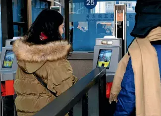  ?? FAIRFAX ?? Passengers pass through a self-service ticket-checking machine at Beijing Railway Station during the Spring Festival in China.