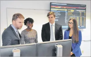  ?? KENN OLIVER/THE TELEGRAM ?? Luke O’brien, vice-president, portfolio manager and wealth adviser at RBC Dominion Securities Inc. in St. John’s, speaks with members of the inaugural cohort for Memorial University’s first student-managed investment portfolio called The Fund at the White Trading Lab. O’brien and Brad White, co-founder, partner and chair of Edgehill Partners in Toronto and namesake for the trading lab, donated a combined $150,000 to make the program possible.