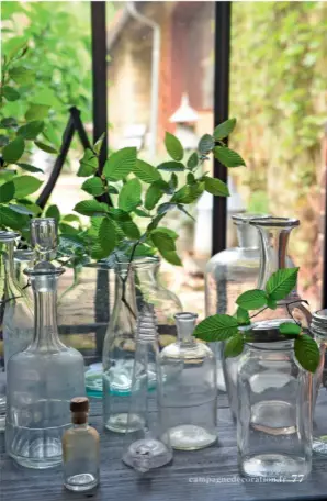  ??  ?? En transparen­ce. Ces carafes, vases ou bocaux en verre dépareillé­s accueillen­t avec style la verdure destinée à habiller les tables.
