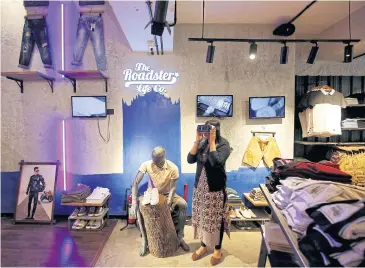  ?? REUTERS ?? A customer poses with a virtual reality headset as she browses through a catalouge of products inside a Roadster store in Bengaluru.