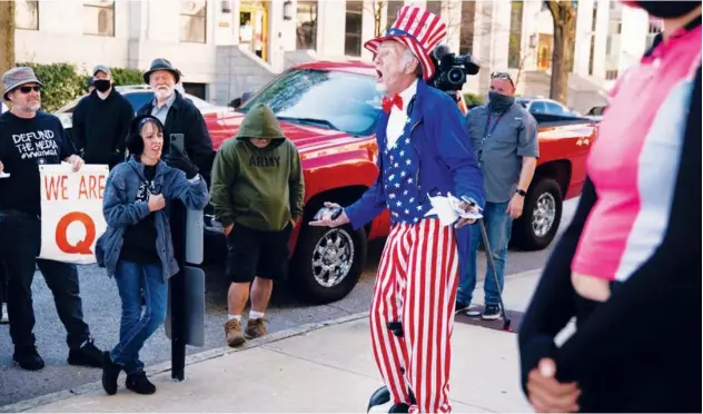  ?? Agence France-presse ?? ↑
A man dressed as Uncle Sam taunts Biden supporters during a ‘Stop the Steal’ rally against the results in Atlanta on Wednesday.