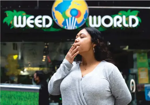  ?? GETTY IMAGES ?? Eliana Miss Illi, general manager of the recreation­al marijuana shop Weed World in New York City, smokes a joint last week.