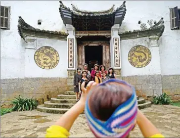  ?? NHAC NGUYEN/AFP ?? Tourists pose for photograph­s at the ancient Hmong heritage palace in Dong Van district in northern Vietnam’s Ha Giang province.