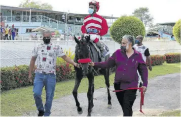  ?? (Photo: Trinidad Guardian) ?? Owner Nigel Amin (right) and trainer Lester Alexis lead Arsalan, the Royal Colours Classic winner, with apprentice Rico Hernandez aboard into the winner’s enclosure at Santa Rosa Park, Arima on Saturday, February 6.