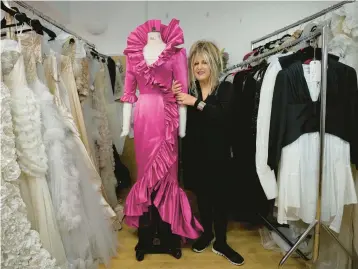  ?? KIN CHEUNG/AP ?? British designer Elizabeth Emanuel stands Nov. 18 beside a replica of an evening gown she designed for then-Lady Diana Spencer to wear at a Buckingham Palace party a few days before her 1981 marriage to Prince Charles in London.