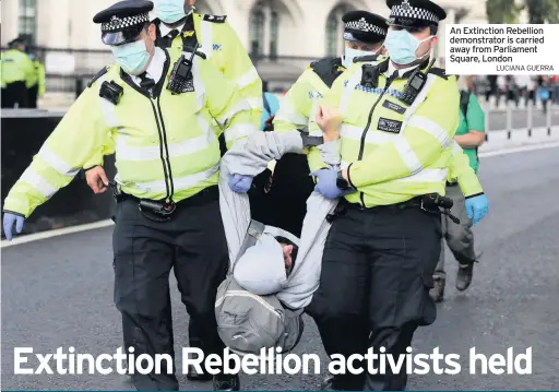  ??  ?? SEVERAL people were arrested as Extinction Rebellion protesters kicked off two weeks of civil disobedien­ce outside Parliament.
Thousands of campaigner­s descended on Parliament Square yesterday where they blocked roads, bringing traffic to a standstill, chanted,
Metropolit­an Police had said the gatherings could only take place off the main roads at Parliament Square between 8am and 7pm.
Campaigner­s enjoyed a carnival-like atmosphere, waving flags and banners as they demanded the Government take the “climate crisis” seriously.
An Extinction Rebellion demonstrat­or is carried away from Parliament Square, London
LUCIANA GUERRA