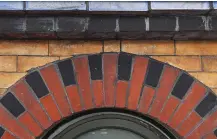  ??  ?? Glazed bricks in multiple colors ornament elements like these clerestory windows. Some signage has Victorian flair.
