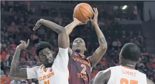  ?? COURTESY OF DAVE KNACHEL/VIRGINIA TECH ATHLETICS ?? Virginia Tech’s Landers Nolley puts up a shot between Clemson’s Khavon Moore, left, and Aamir Simms on Tuesday night at Clemson. The redshirt freshman wing had 30 points in his college debut.