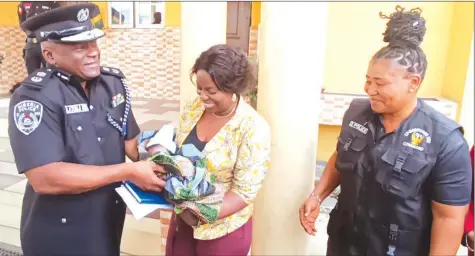  ?? ?? Rivers State Commission­er of Police ( CP), Tunji Disu ( left), receiving one of the recovered babies from Commander, Police Monitoring Unit ( PMU) in the state, CSP Grace Wonwu and DSP Agnes Ovunda at the state command, in Port Harcourt… yesterday.
