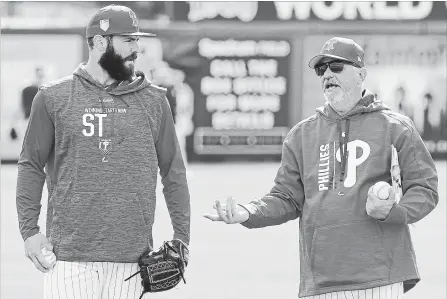  ?? JOHN RAOUX THE ASSOCIATED PRESS ?? Philadelph­ia Phillies pitcher Jake Arrieta, left, talks with pitching coach Rick Krannitz during a workout on Tuesday in Clearwater, Fla.