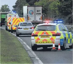  ??  ?? Police at the scene of the incident on the A90 north of Forfar.