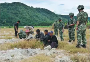  ?? WEI LIPENG / FOR CHINA DAILY ?? Above: Police seize trafficker­s in a border area of Yunnan.