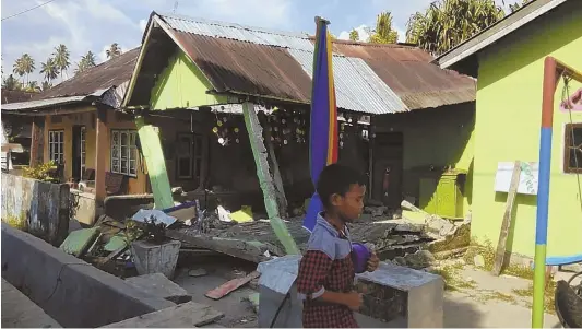  ?? AP PHOTO ?? AFTERMATH: An earthquake-damaged home is seen on the Indonesian island of Sulawesi after the area was struck by a 7.5-magnitute temblor. The island’s coast was hit by a 10-foot tsunami after the quake.