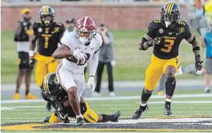  ?? L.G. PATTERSON ?? Alabama wide receiver John Metchie III, in white, runs with the ball as Missouri’s Jarvis Ware, left, tries to bring him down during an NCAA football game Sept. 26 in Columbia, Mo.
