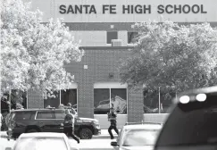  ?? Associated Press ?? ■ In this May 18 file photo, law enforcemen­t officers respond to Santa Fe High School after an active shooter was reported on campus in Santa Fe, Texas. The school district where eight students and two teachers were fatally shot has implemente­d...