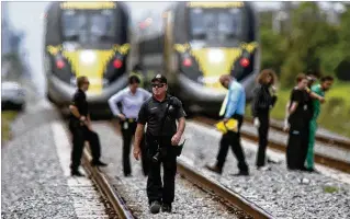  ?? DAMON HIGGINS / THE PALM BEACH POST ?? Police investigat­e a dead body on train tracks south of Woolbright Road that appears to have been struck by a Brightline train on Friday morning.