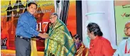  ??  ?? Lifetime Achievemen­t Award: A.S. Fernando receives the Traditiona­l Golden Shawl from Managing Director of Yarl Thinakural, Dr. P. Kesavaraj