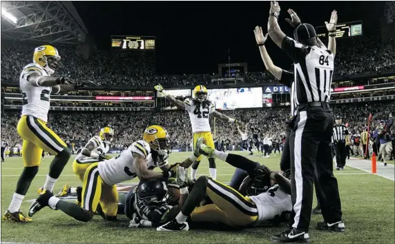  ?? — THE ASSOCIATED PRESS FILES ?? Officials signal after Seattle wide receiver Golden Tate pulls in a last-second pass from quarterbac­k Russell Wilson to defeat Green Bay 14-12 in September. Packers safety M.D. Jennings was on the wrong end of the call, as the touchdown stood after...