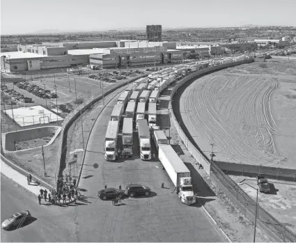  ?? OMAR ORNELAS/THE EL PASO TIMES/USA TODAY NETWORK ?? A long line of trucks is stalled at the Zaragoza Internatio­nal Bridge, one of two ports of entry in Ciudad Juarez going into the U.S. The truckers blocked northbound and southbound commercial lanes in protest after they experience­d prolonged processing times implemente­d by Gov. Greg Abbott.