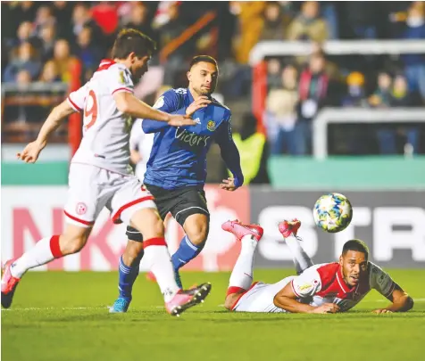  ?? — PICTURE ALLIANCE VIA GETTY IMAGES ?? FC Saarbrücke­n’s Kianz Froese, in blue, battles against Fortuna Düsseldorf’s Markus Suttner, left, and Zanka. Froese’s club has been promoted from fourth division to third.