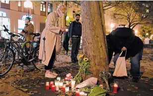  ?? THOMAS KRONSTEINE­R GETTY IMAGES ?? People place candles at a crime scene in the city centre the day after a deadly shooting spree in Vienna. One gunman was shot and killed by police.