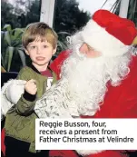  ??  ?? Reggie Busson, four, receives a present from Father Christmas at Velindre