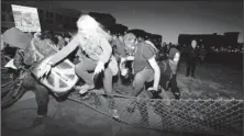  ?? By Kimihiro Hoshino, Afp/getty Images ?? Protesters from Occupy Oakland knock over fences set up by police to surround and detain them on a vacant lot in Oakland.