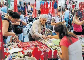  ??  ?? Movimiento. El barrio se llenó de puestos con artículos del santo.