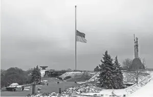  ?? BERNAT ARMANGUE/AP ?? The Ukrainian flag flutters at half-mast near the Ukrainian Motherland monument in Kyiv. The Ukrainian capital city saw continued interrupti­ons to its electricit­y, heat and water supply, Mayor Vitali Klitschko said Tuesday.