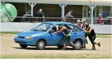  ??  ?? Teams push cars as part of the fitness event.