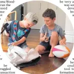  ??  ?? Kids involved in the trial check out the new electronic­ally-tagged rugby ball.