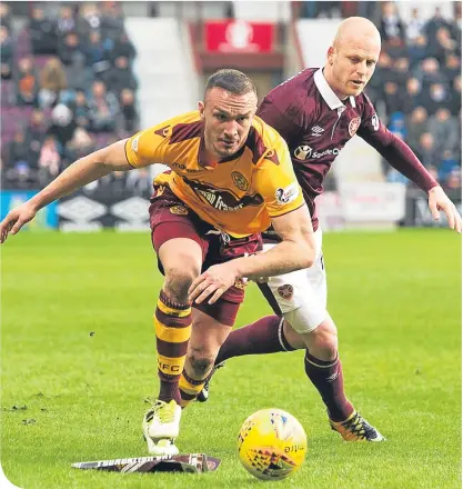  ??  ?? Motherwell’s Tom Aldred shields the ball from Hearts’ transfer window arrival Steven Naismith