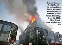  ??  ?? Smoke rises as firefighte­rs try to extinguish a fire at an eightfloor building in Jecheon, South Korea, Thursday, Dec. 21, 2017. (Kim Hyungwoo/Yonhap via AP)