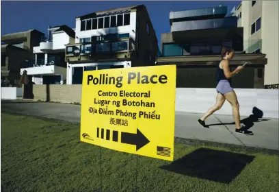  ?? GREGORY BULL — ASSOCIATIO­N PRESS FILE ?? A woman runs on a path by a polling place during primary elections in San Diego in March. There are a number of propositio­ns on the November ballot to know.