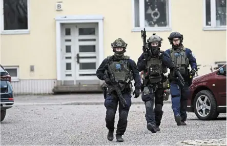  ?? — Reuters ?? Standing guard: police officers walking at the Viertola comprehens­ive school in Vantaa, Finland.