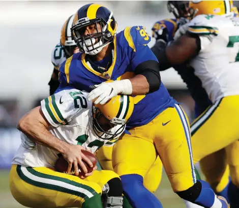  ?? MARCIO JOSE SANCHEZ/THE ASSOCIATED PRESS ?? Rams defensive tackle Aaron Donald sacks Green Bay Packers quarterbac­k Aaron Rodgers during Sunday’s back-and-forth game in Los Angeles that saw the Rams remain undefeated and improve to 8-0 on the season with a 29-27 victory.