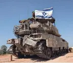  ?? AMIR COHEN/REUTERS ?? Israeli soldiers mount an Israeli flag on a military vehicle Monday at a site in Israel near the border with Gaza.