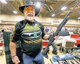  ?? POSTMEDIA ?? A collector holds an SKS rifle at a Calgary gun show on Sept. 21, 2019. The SKS, a precursor to the AK-47, is one of the rifles not covered by the Liberals’ recent ban on “military-style” firearms.