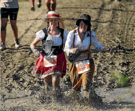  ?? PHOTO: DAVID UNWIN/STUFF ?? Gizz Walker and Buzz Walker make their way through the mud in the Tough Guy and Gal Challenge at Linton Military Camp.