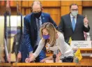  ?? EDDIE MOORE/JOURNAL ?? Freshman Sen. Siah Correa Hemphill, D-Silver City, signs paperwork on the Senate floor Tuesday as Majority Leader Peter Wirth, D-Santa Fe, looks on.