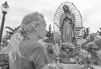  ?? PHOTOS BY NATHAN J. FISH/THE OKLAHOMAN ?? After participat­ing in a pilgrimage walk from Moore to the Blessed Stanley Rother Shrine on Thursday, Anna Arra stands in front of a statue of Our Lady of Guadalupe atop Tepeyac Hill on the grounds of the shrine, 700 SE 89.