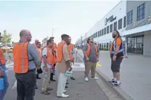  ??  ?? Mike Fina (right), a trainer, gets ready to lead a group of applicants on a tour through the Amazon fulfillmen­t center so they can better understand jobs they are applying for.