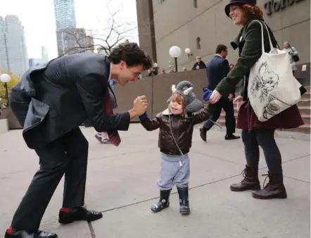  ?? RICHARD LAUTENS/TORONTO STAR ?? HIGH OFFICE HIGH-FIVE Justin Trudeau greets Thomas Promoli-McGee, 2, and mom, Jill, as the prime minister arrives for a meeting at the Star.