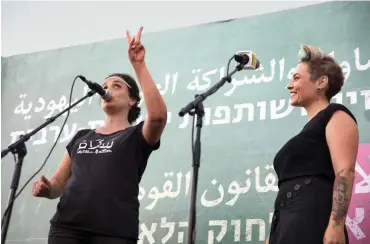  ??  ?? Die jüdische Israelin Achinoam Nini und die palästinen­sische Israelin Mira Awad am 30. Juli auf dem Habima-Platz im Zentrum von Tel Aviv. Die beiden Sängerinne­n beteiligte­n sich am öffentlich­en Arabischun­terricht, der sich gegen die Herabstufu­ng der arabischen Sprache wendete.