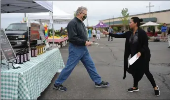  ?? NEWS-SENTINEL PHOTOGRAPH­S BY BEA AHBECK ?? Pat Patrick, CEO and president of the Lodi Chamber of Commerce and Marina Navarte, the chamber director of membership, puts out social distancing markers before the first “Essential” Farmers Market in the temporary location in the parking lot at the First Baptist Church of Lodi and Millswood Middle School on Thursday.