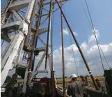  ?? John Davenport / San Antonio Express-News ?? Roughneck Eluid Cervantes pulls up a section of drilling pipe with the help of machinery at an Abraxus Petroleum rig in Atascosa County this May.