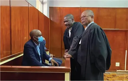  ?? ?? Dr. Thapelo Matsheka ( seated) in consultati­on with his lawyers during a recent court appearance