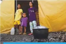  ?? —AFP ?? BALO-I, Philippine­s: Young evacuees cook rice in front of their tent at an evacuation centre in Balo-i town, Lanao del Sur province, on the southern island of Mindanao.